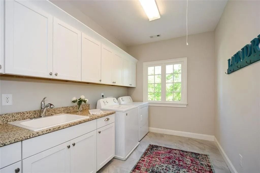 A laundry room with a washer and dryer and a sink