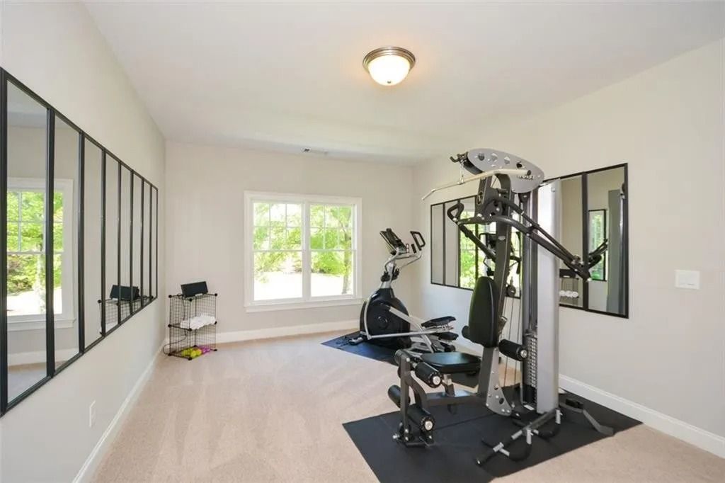 A home gym with a lot of mirrors and exercise equipment