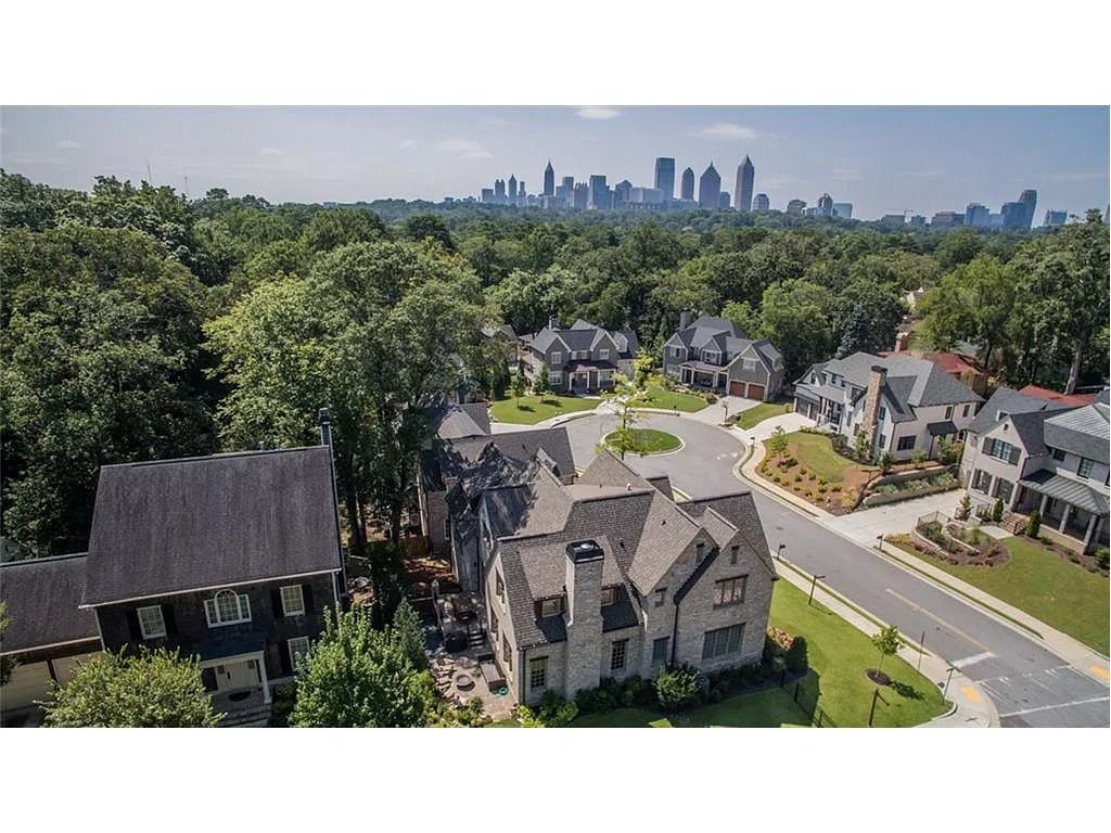 An aerial view of a residential neighborhood with a city skyline in the background.