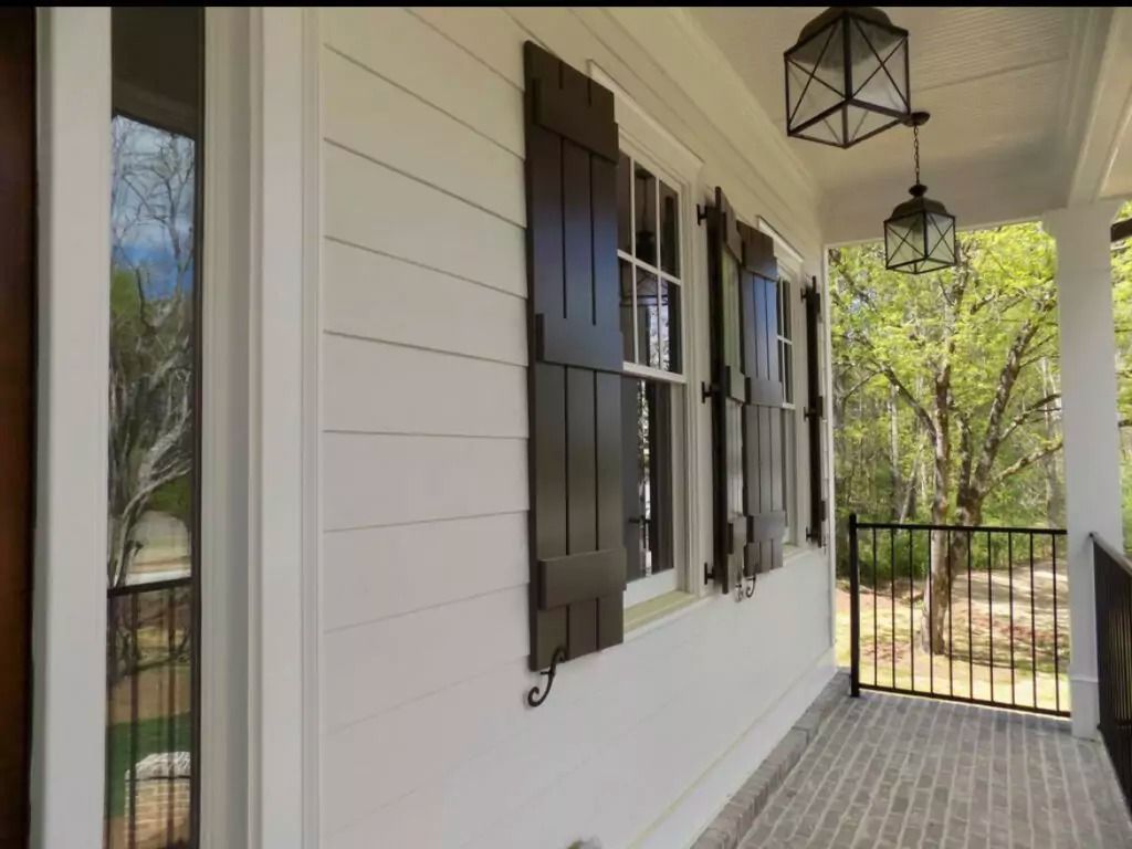 A white house with brown shutters on the windows