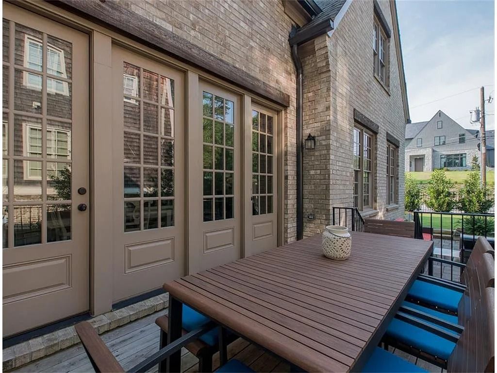 A patio with a table and chairs in front of a brick building.