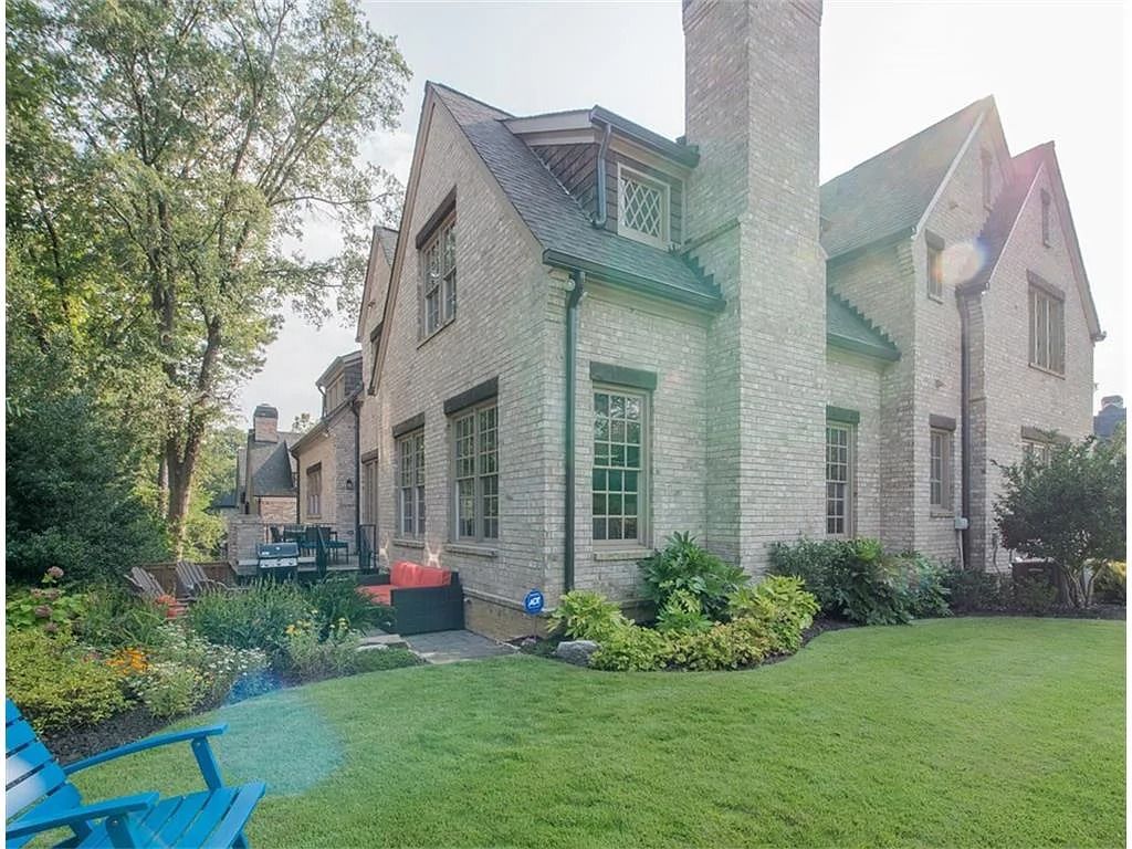 A large brick house with a blue chair in front of it