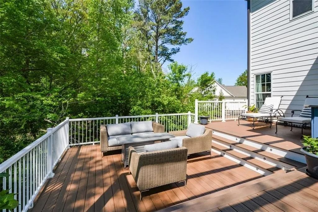 A large deck with a couch and chairs on it