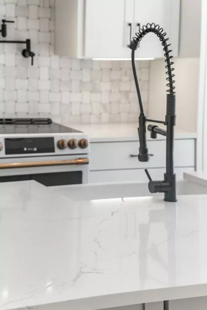 A kitchen with a sink , stove , and oven.