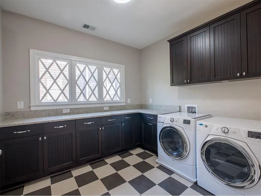 A laundry room with a washer and dryer and a checkered floor.