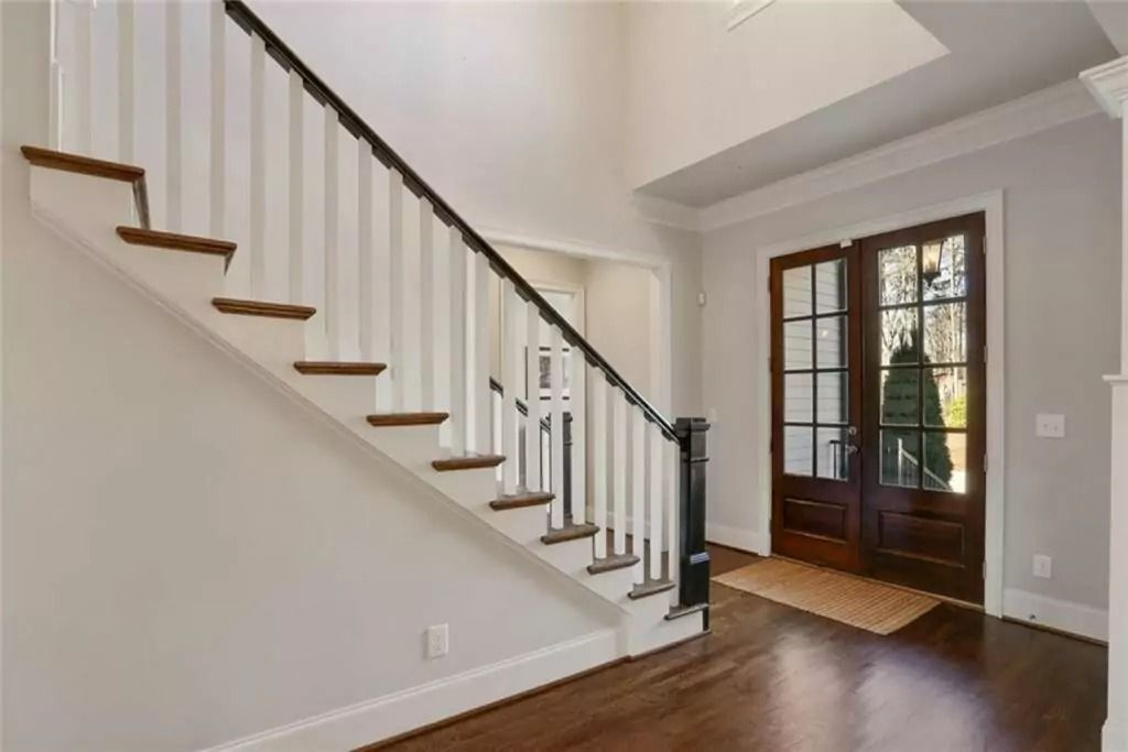 A staircase in a house with a white railing and wooden steps