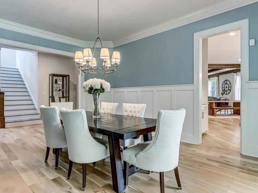 A dining room with a table and chairs and a chandelier.