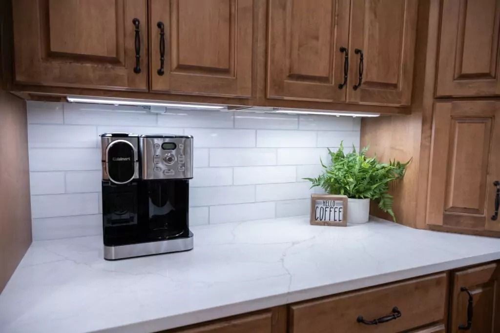 A coffee maker is sitting on a counter in a kitchen.