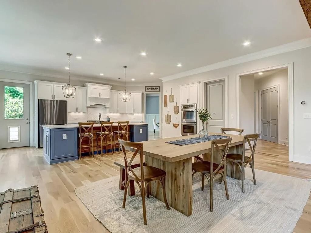 A kitchen and dining room in a house with a wooden table and chairs.