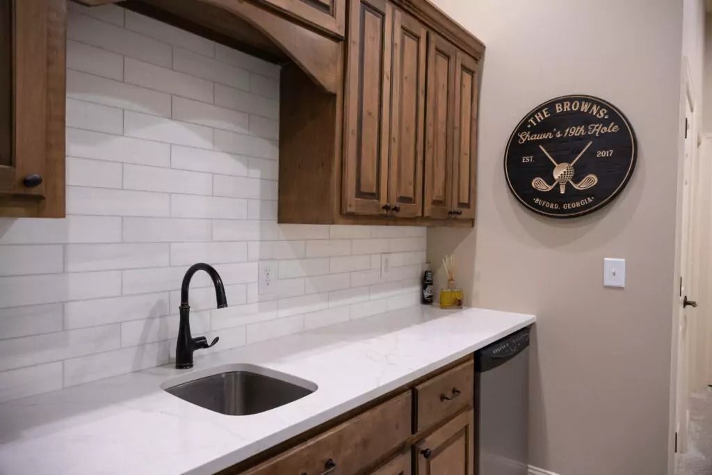 A kitchen with a sink and a clock on the wall.