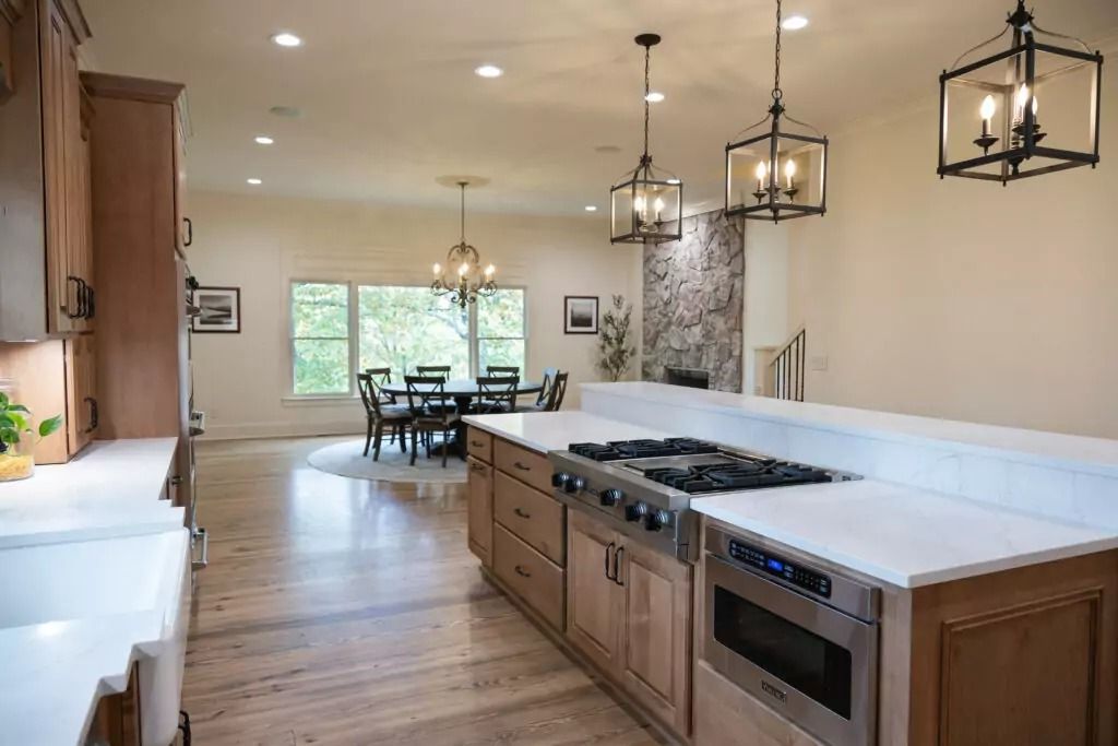A kitchen with a large island and a stove top oven.