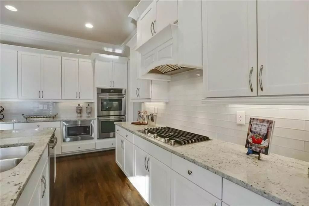 A kitchen with white cabinets and granite counter tops
