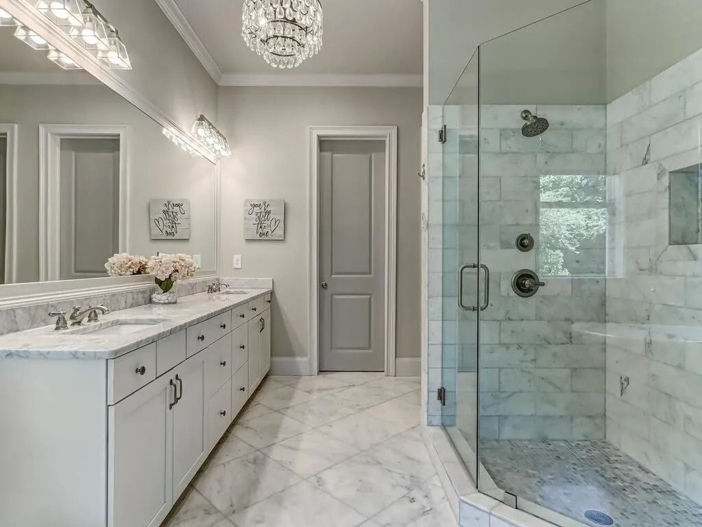 A bathroom with two sinks and a walk in shower.
