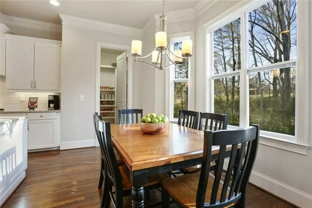 A dining room with a table and chairs and a chandelier