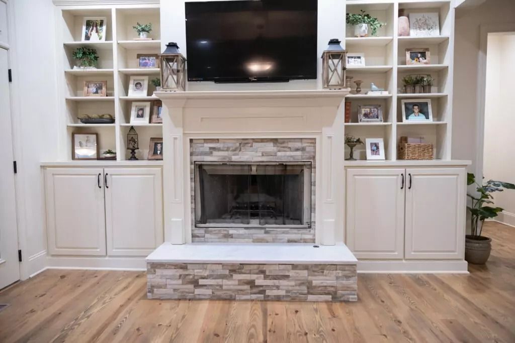 A living room with a fireplace and a flat screen tv.