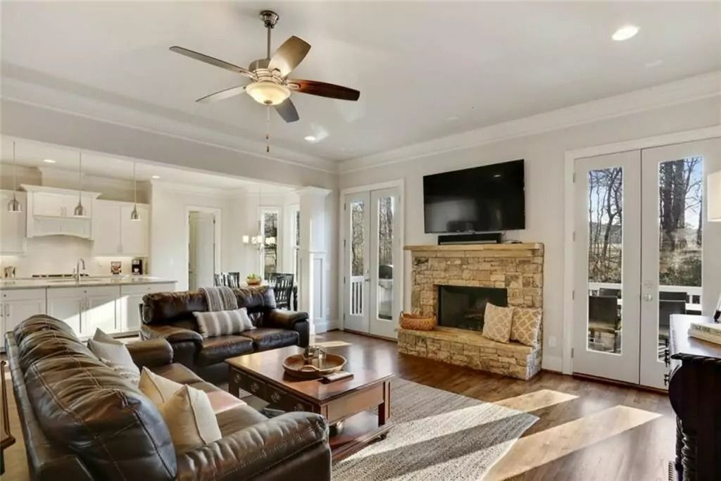 A living room with a ceiling fan and a fireplace