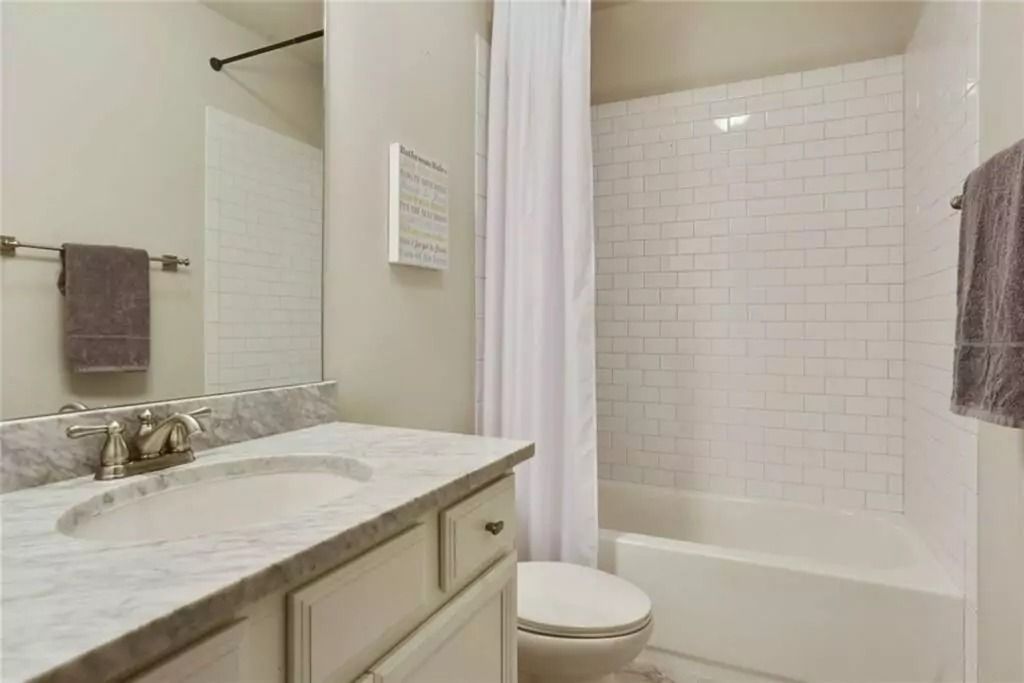 A bathroom with a sink , toilet , bathtub and mirror.