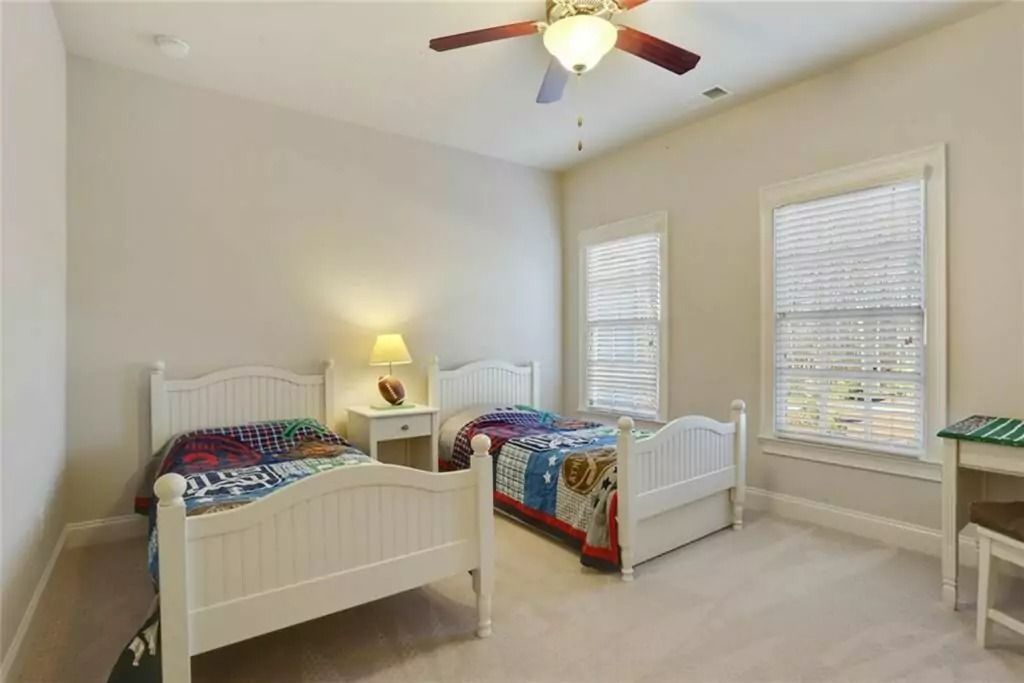 A bedroom with two beds and a ceiling fan
