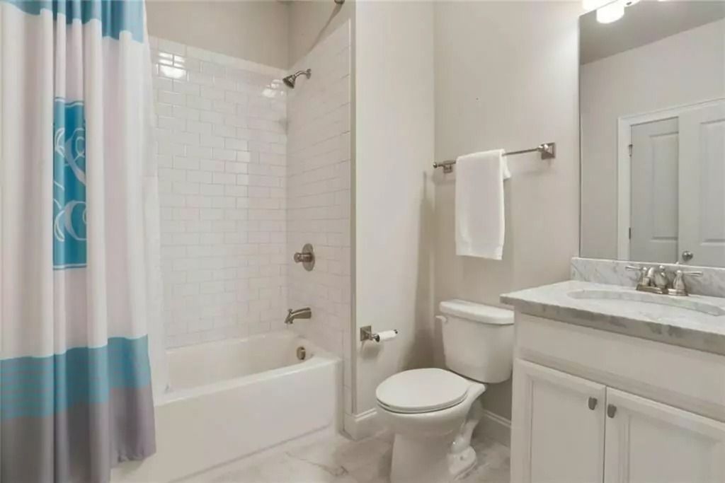 A bathroom with a toilet , sink , tub and shower.