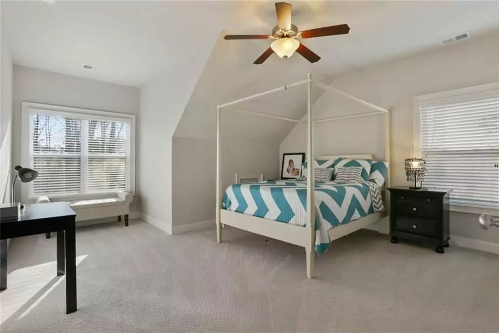 A bedroom with a canopy bed and a ceiling fan