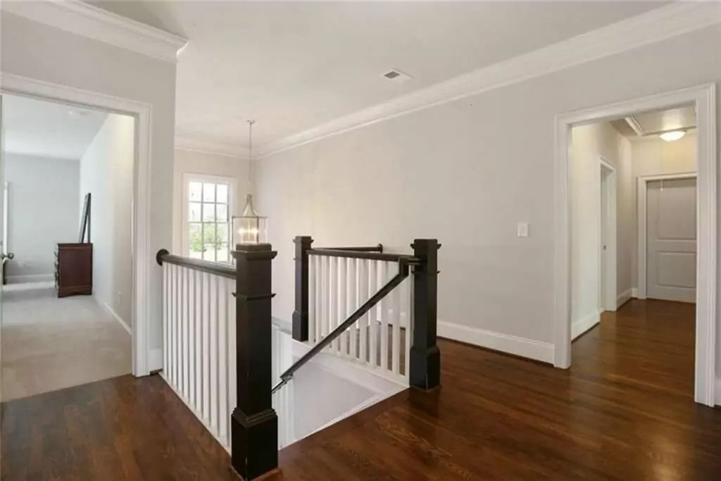 There is a staircase with a black railing in the middle of the room.