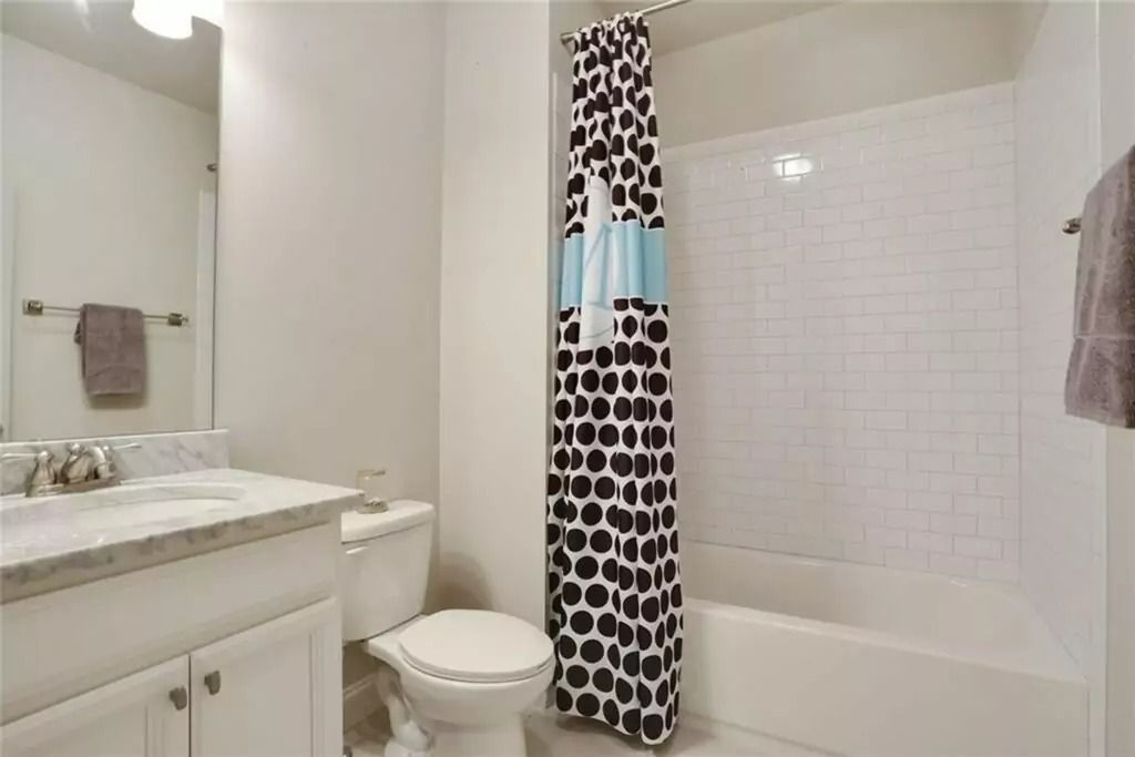 A bathroom with a toilet , sink , shower and bathtub.