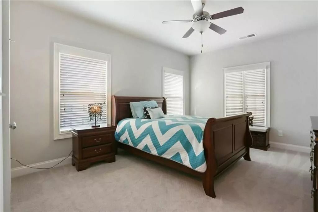 A bedroom with a bed , nightstand , and ceiling fan.