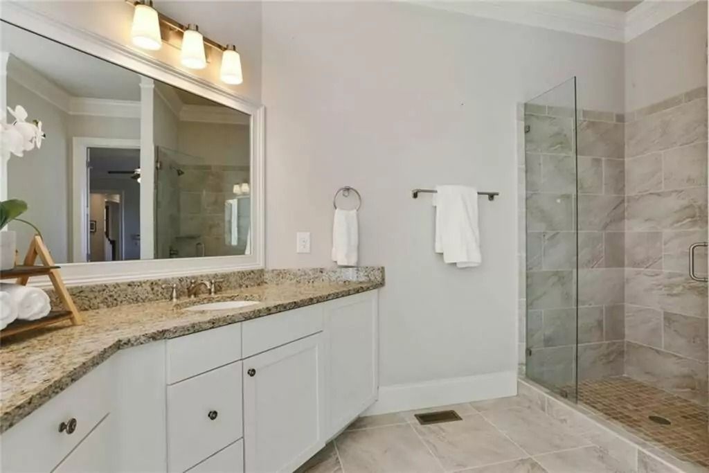 A bathroom with two sinks and a walk in shower