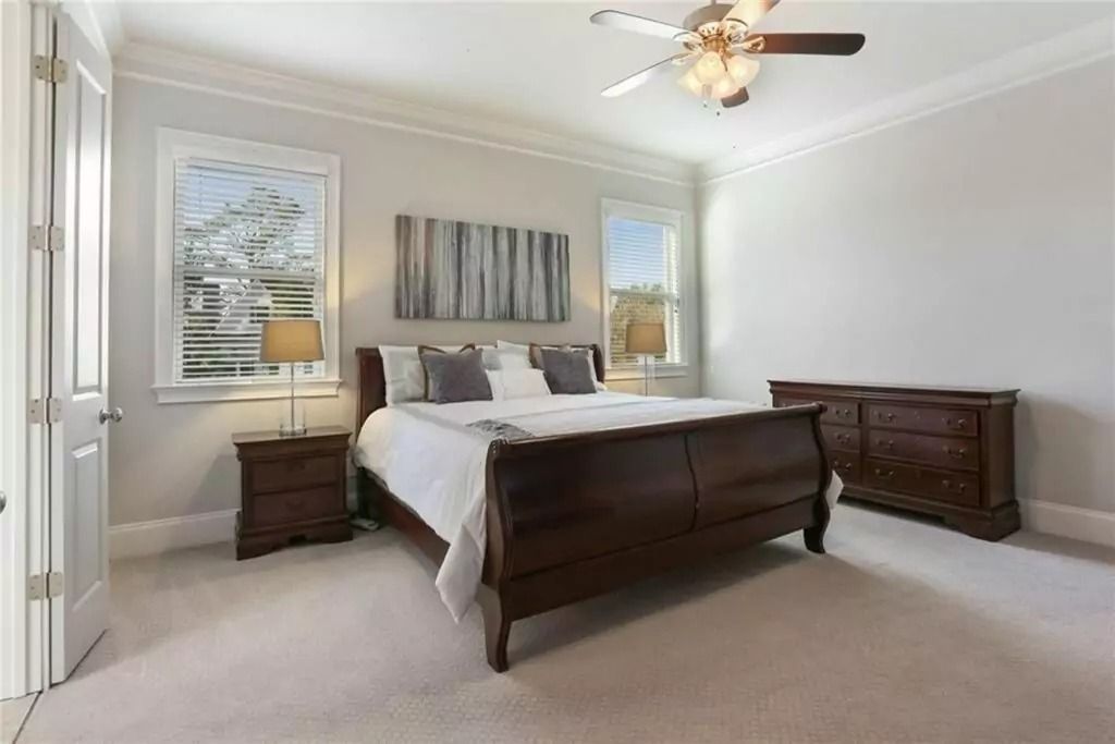 A bedroom with a king size bed and a ceiling fan.