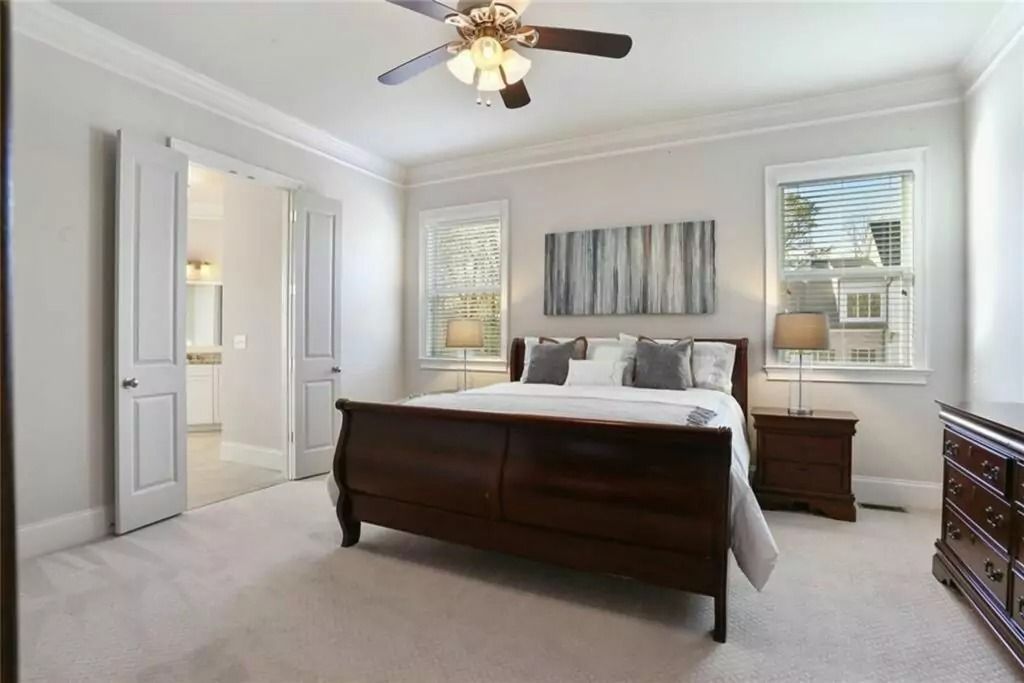 A bedroom with a king size bed and a ceiling fan.