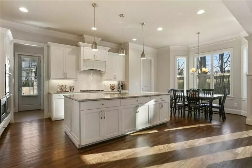 A large kitchen with white cabinets and a large island in the middle.