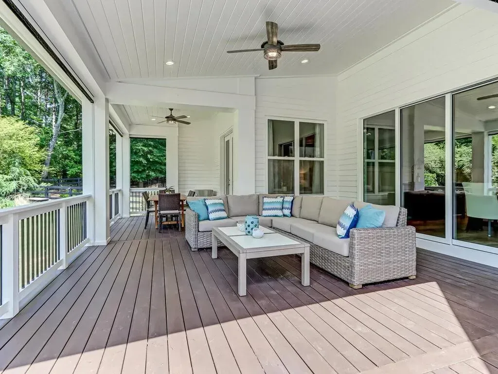 A large porch with furniture and a ceiling fan