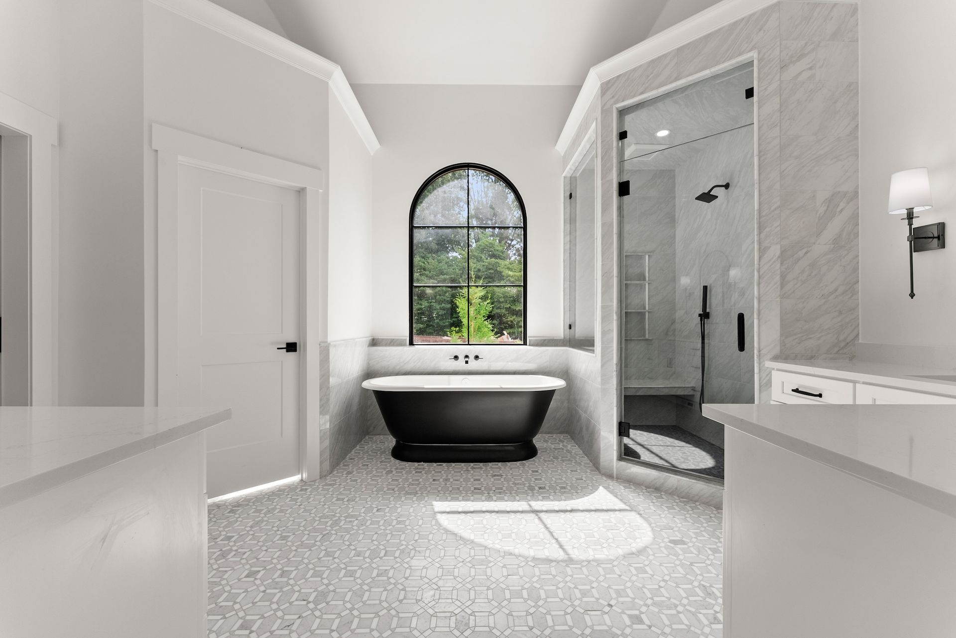 A bathroom with a black tub and a window.
