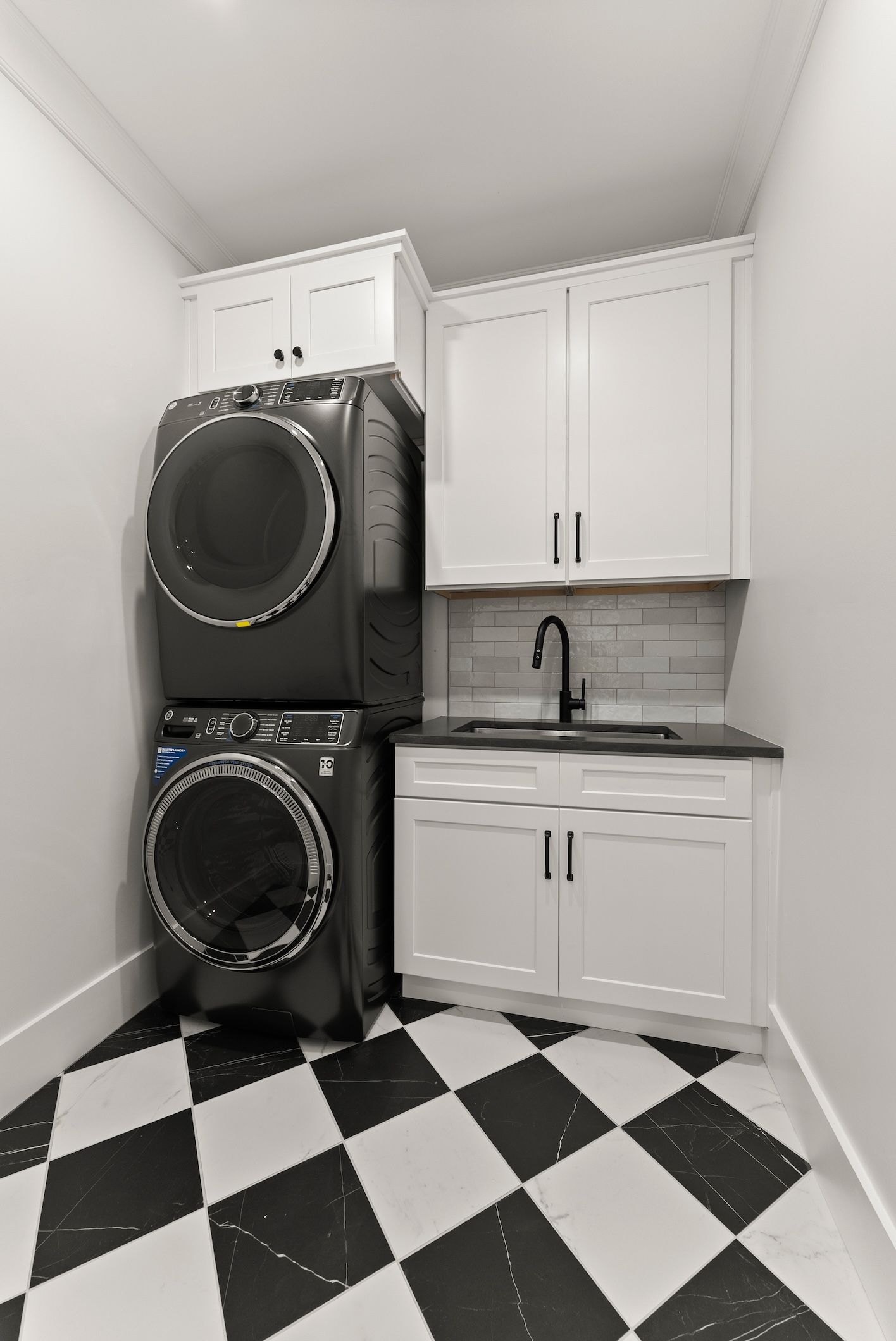A washer and dryer are stacked on top of each other in a laundry room.
