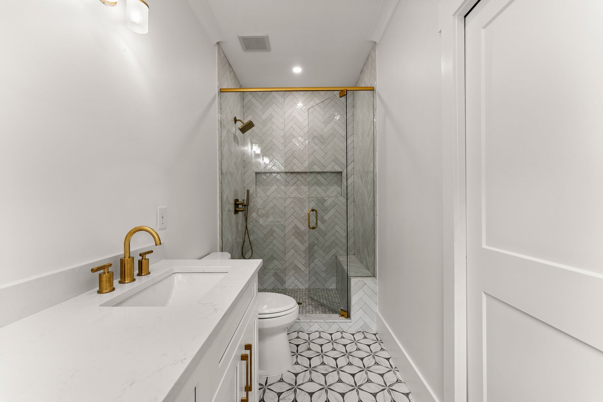 A bathroom with a sink , toilet and walk in shower.