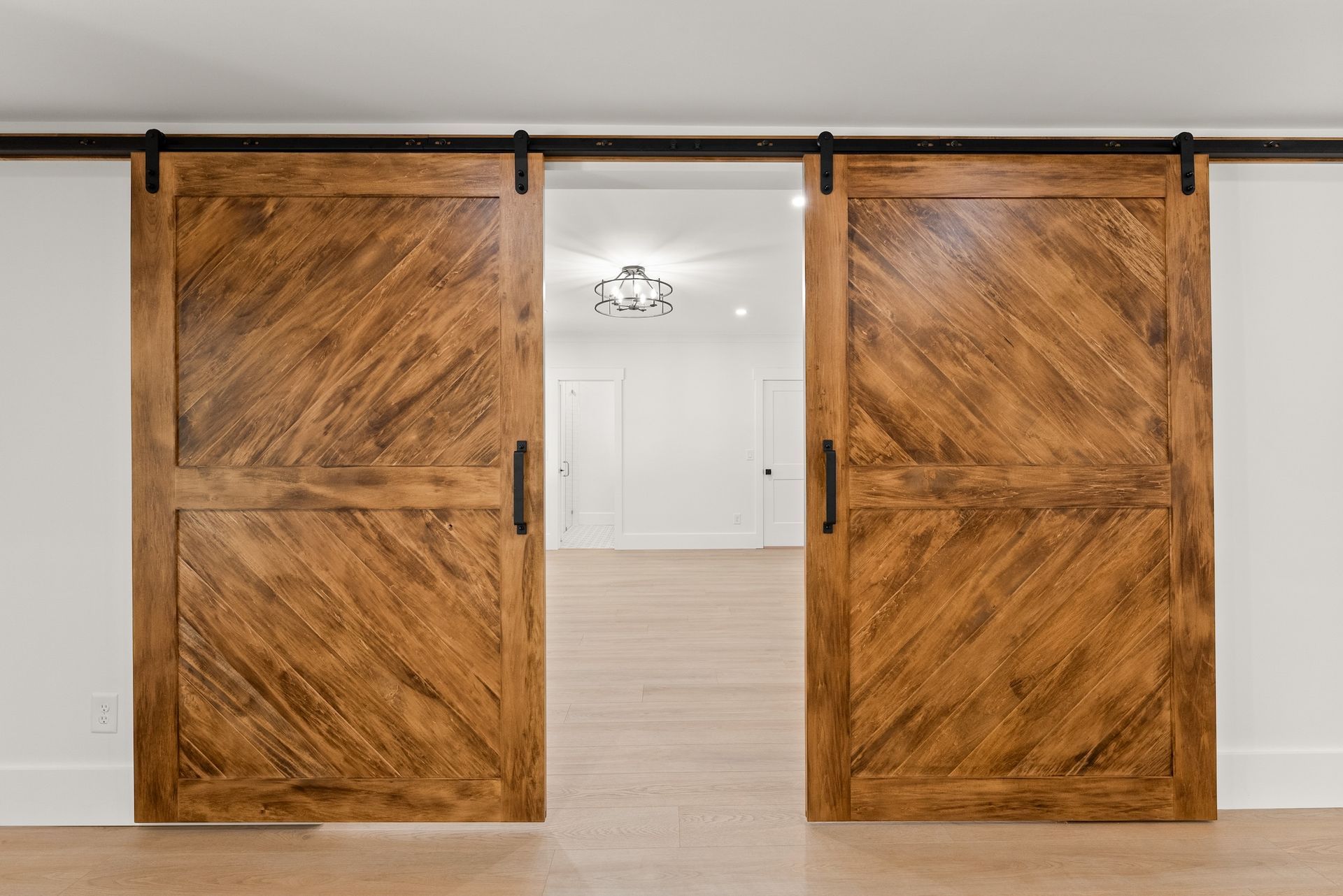 A pair of wooden sliding barn doors in an empty room.