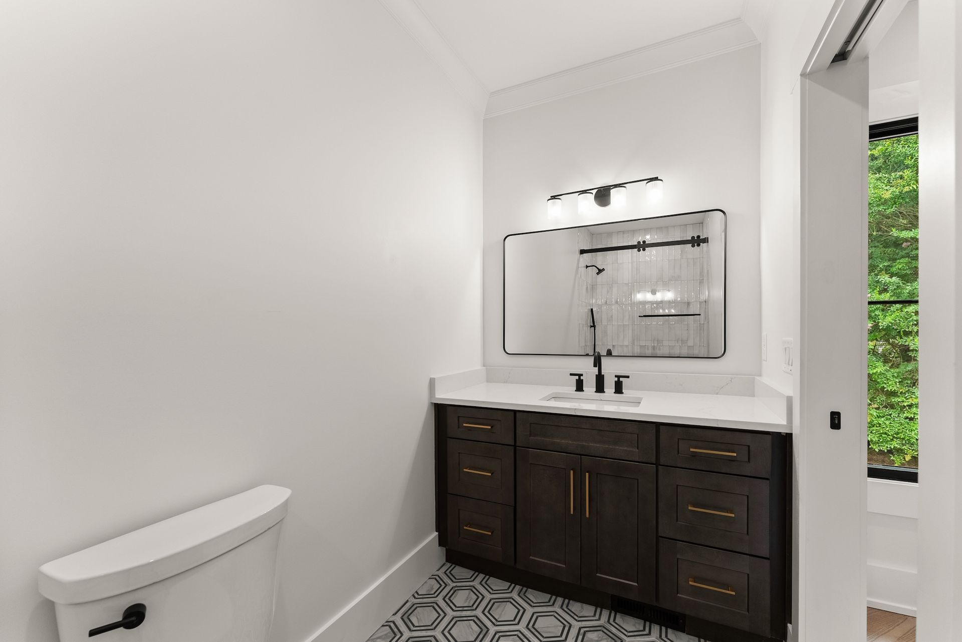 A bathroom with a toilet , sink , and mirror.