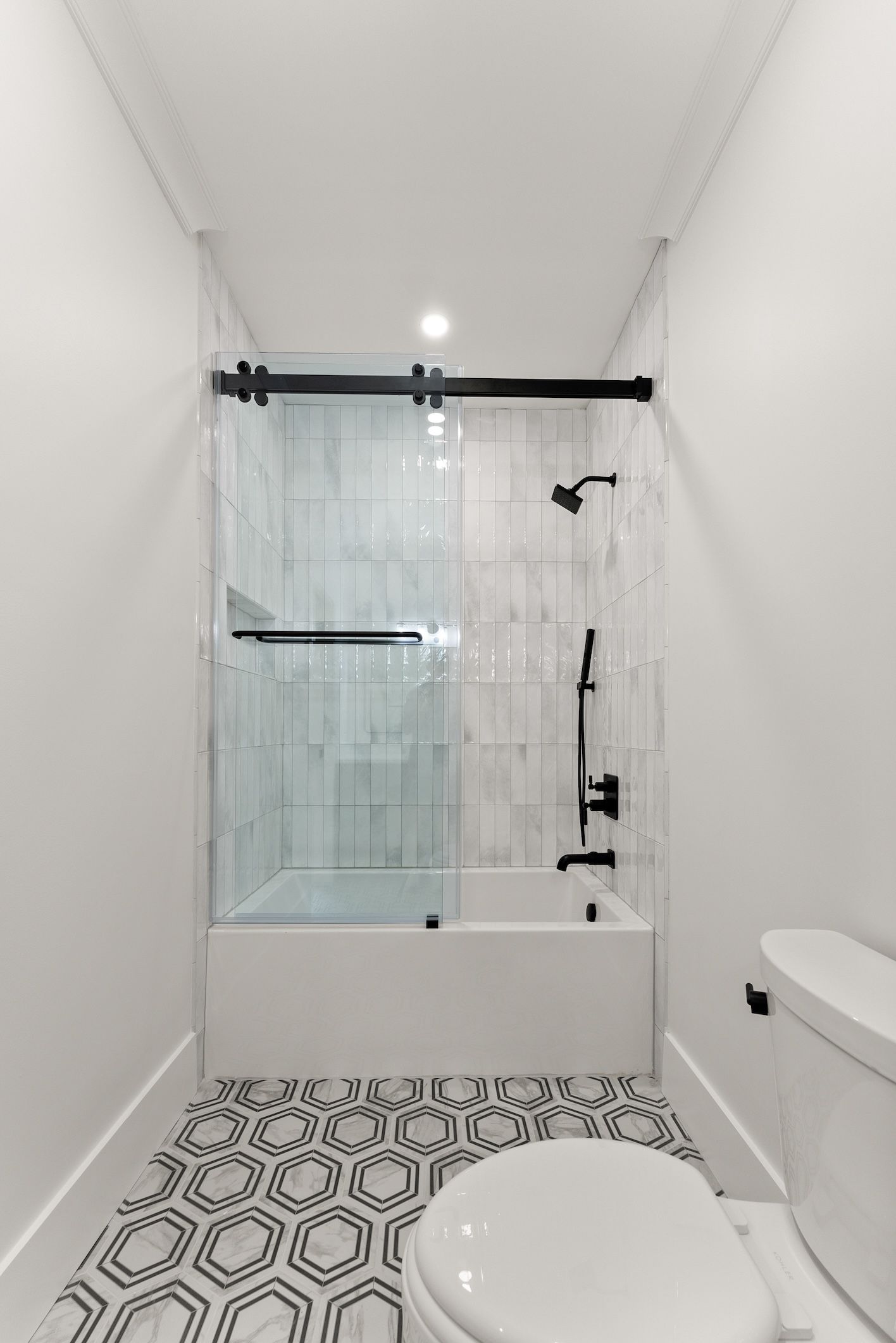 A bathroom with a toilet , tub and shower.