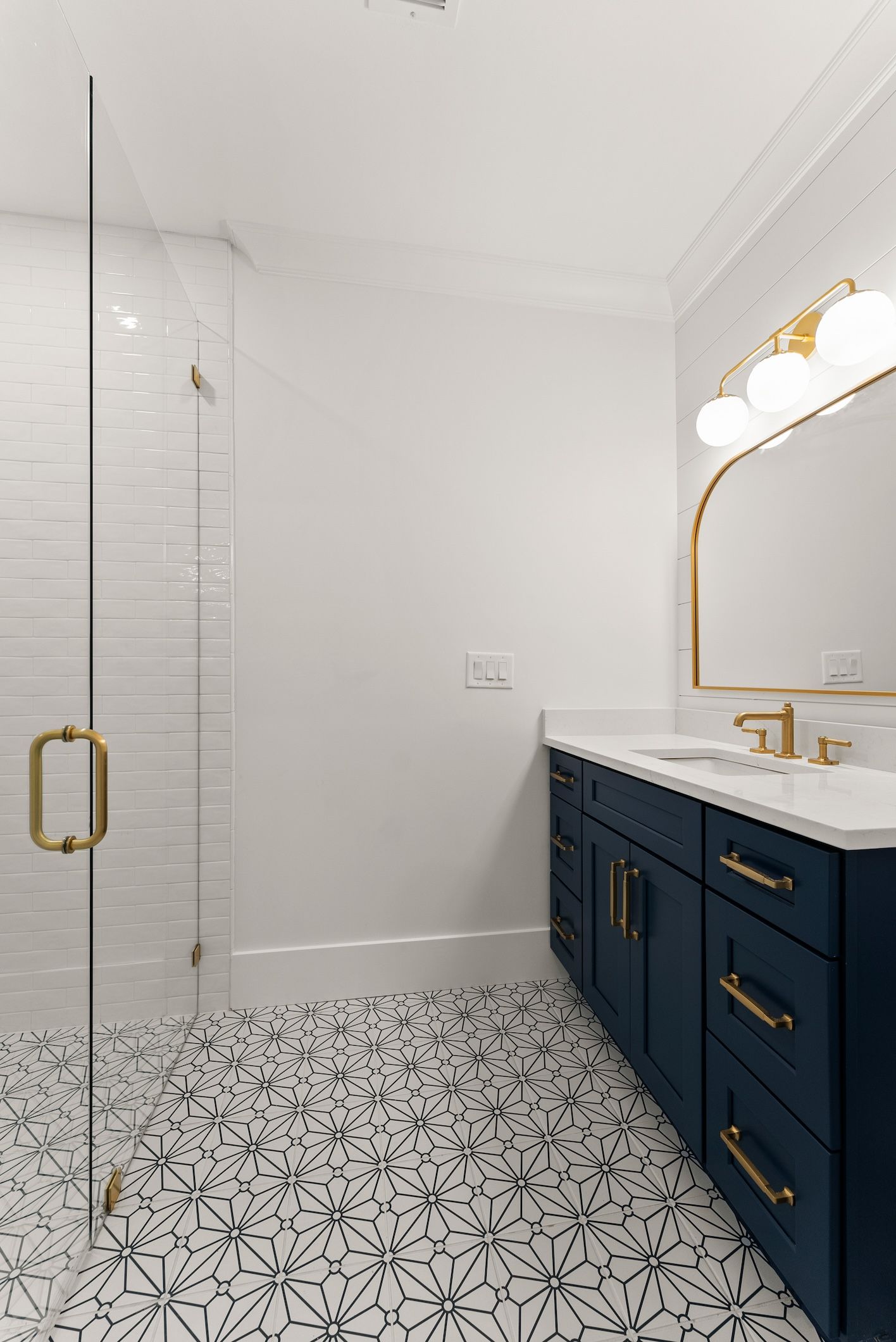 A bathroom with two sinks , a shower , and a mirror.