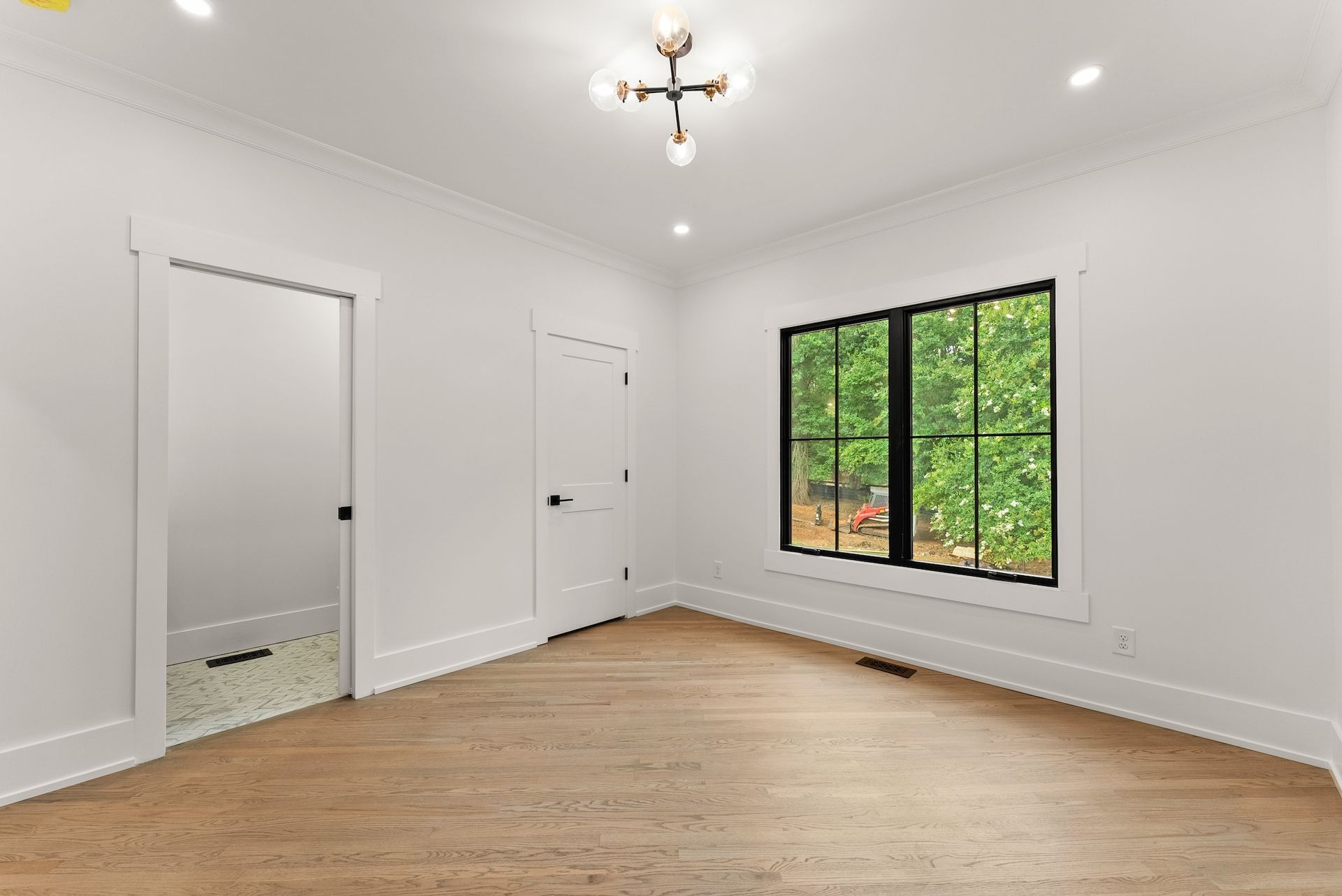 An empty room with hardwood floors and two windows.