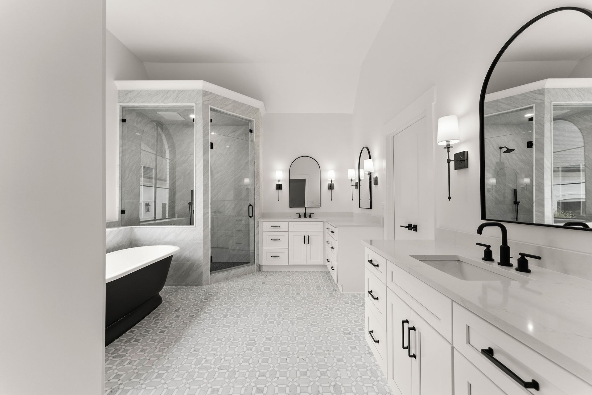 A black and white photo of a bathroom with a bathtub , sink , mirror and shower.