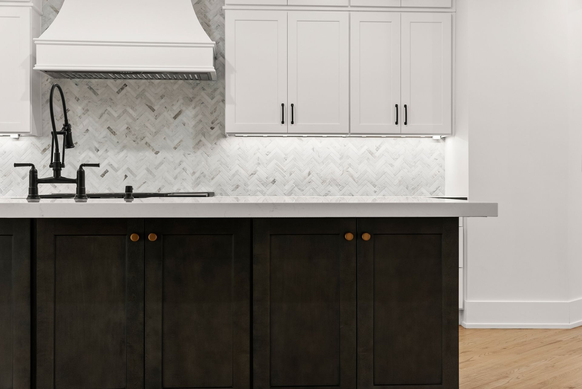 A kitchen with white cabinets and black cabinets and a stove top oven.
