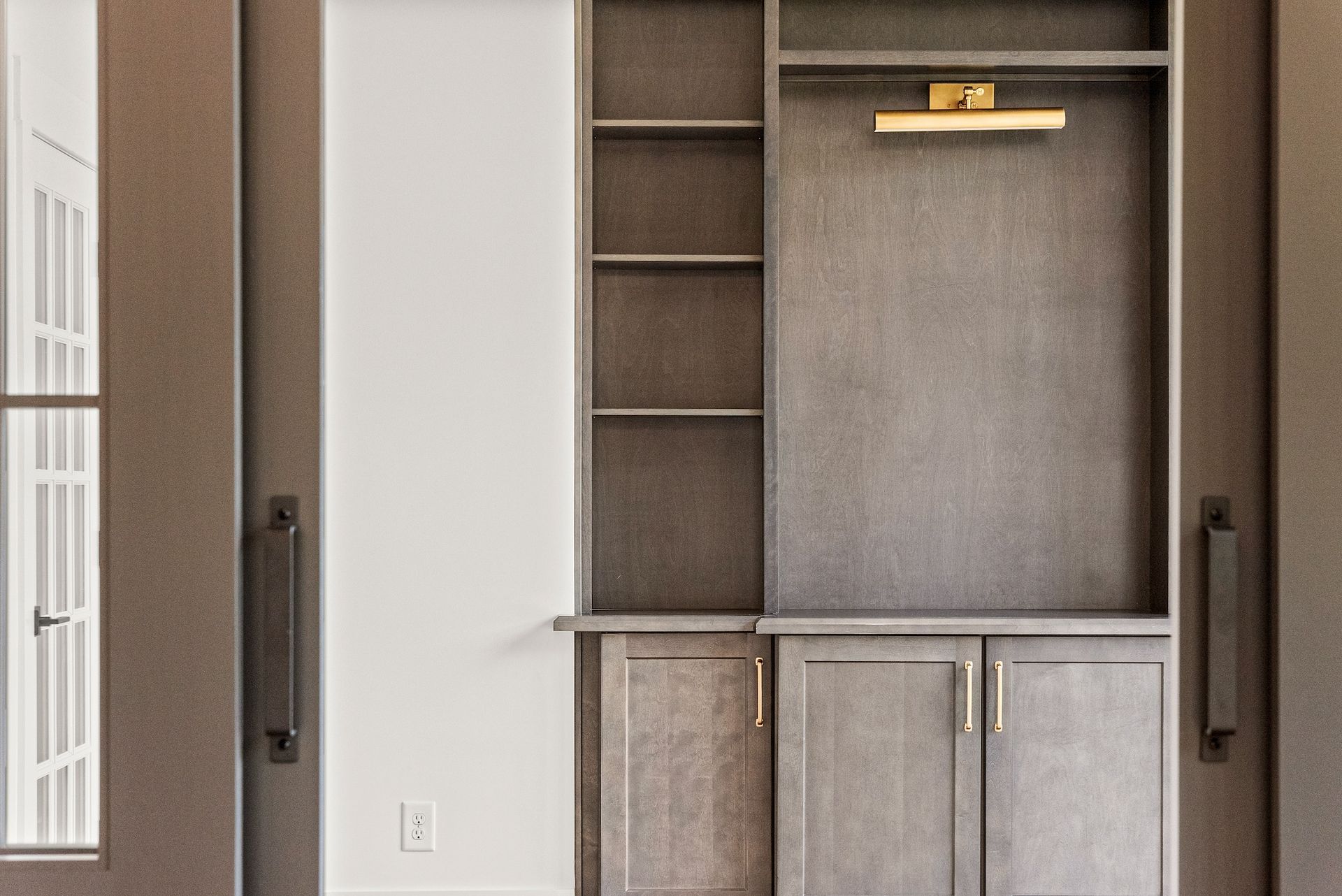 A living room with a built in entertainment center and sliding glass doors.