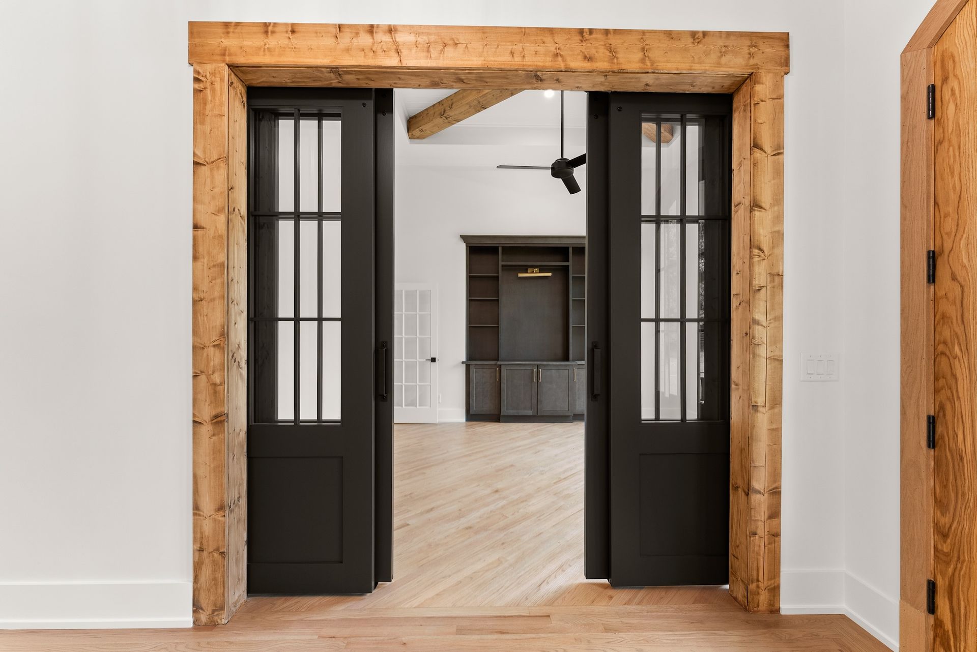 A room with two black sliding doors leading to a living room.