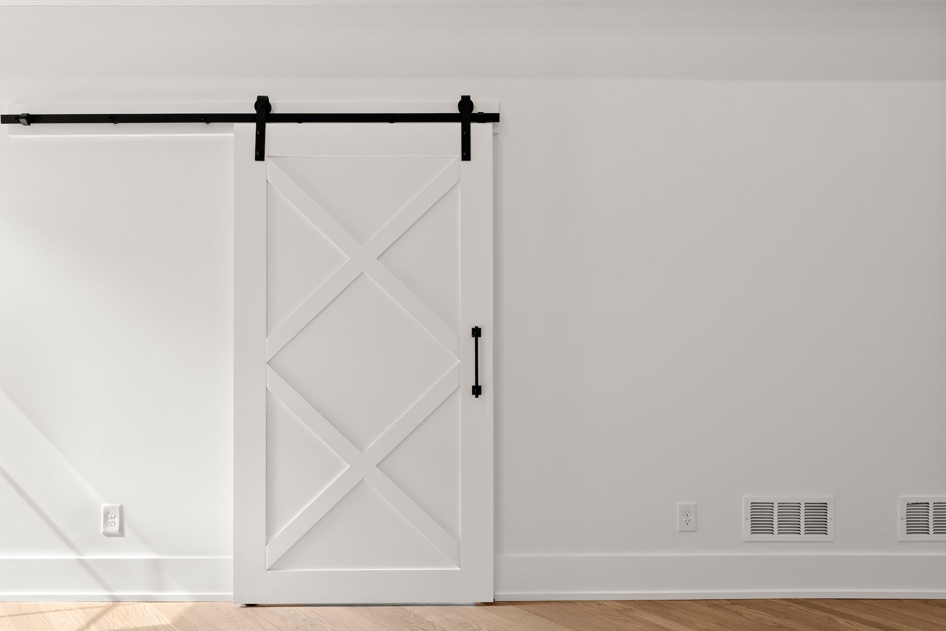 There is a sliding barn door in the corner of the room.