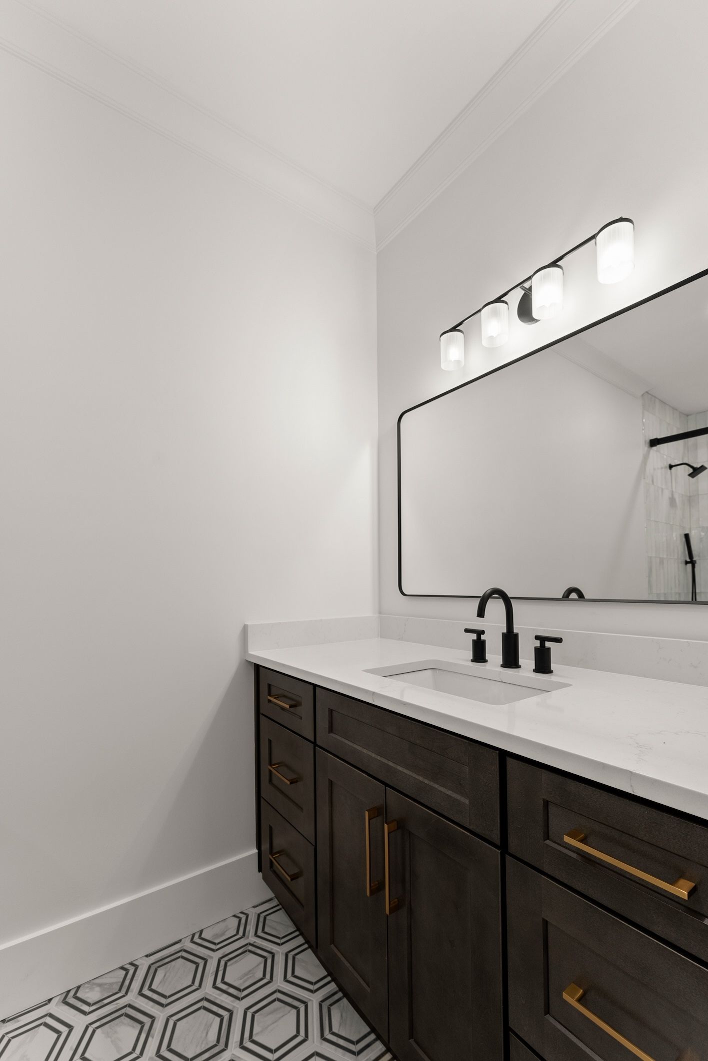 A bathroom with a sink , mirror and cabinets.