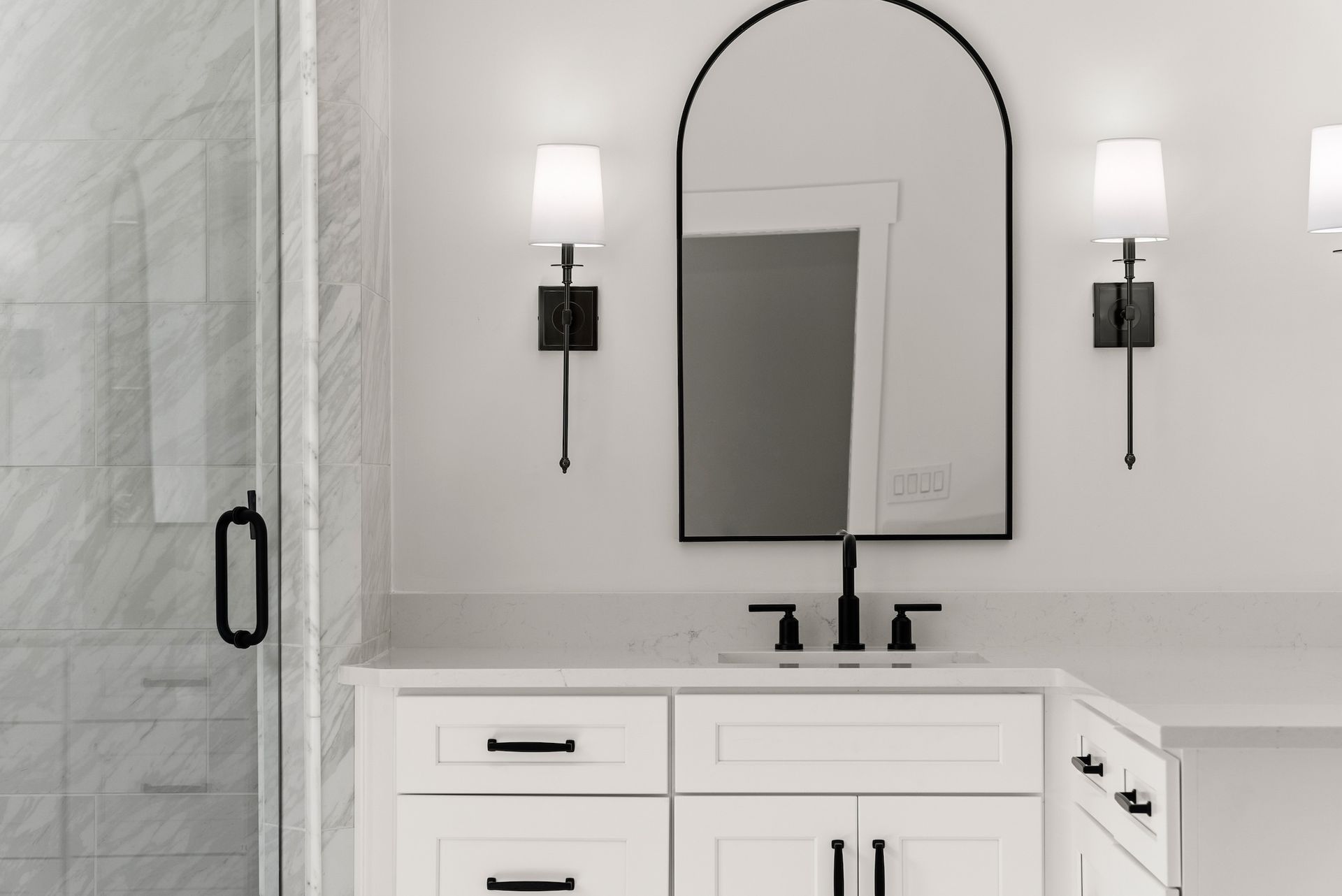 A bathroom with a sink , mirror , and shower.