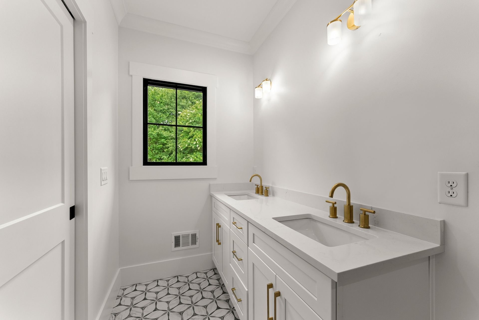 A bathroom with two sinks and a window.