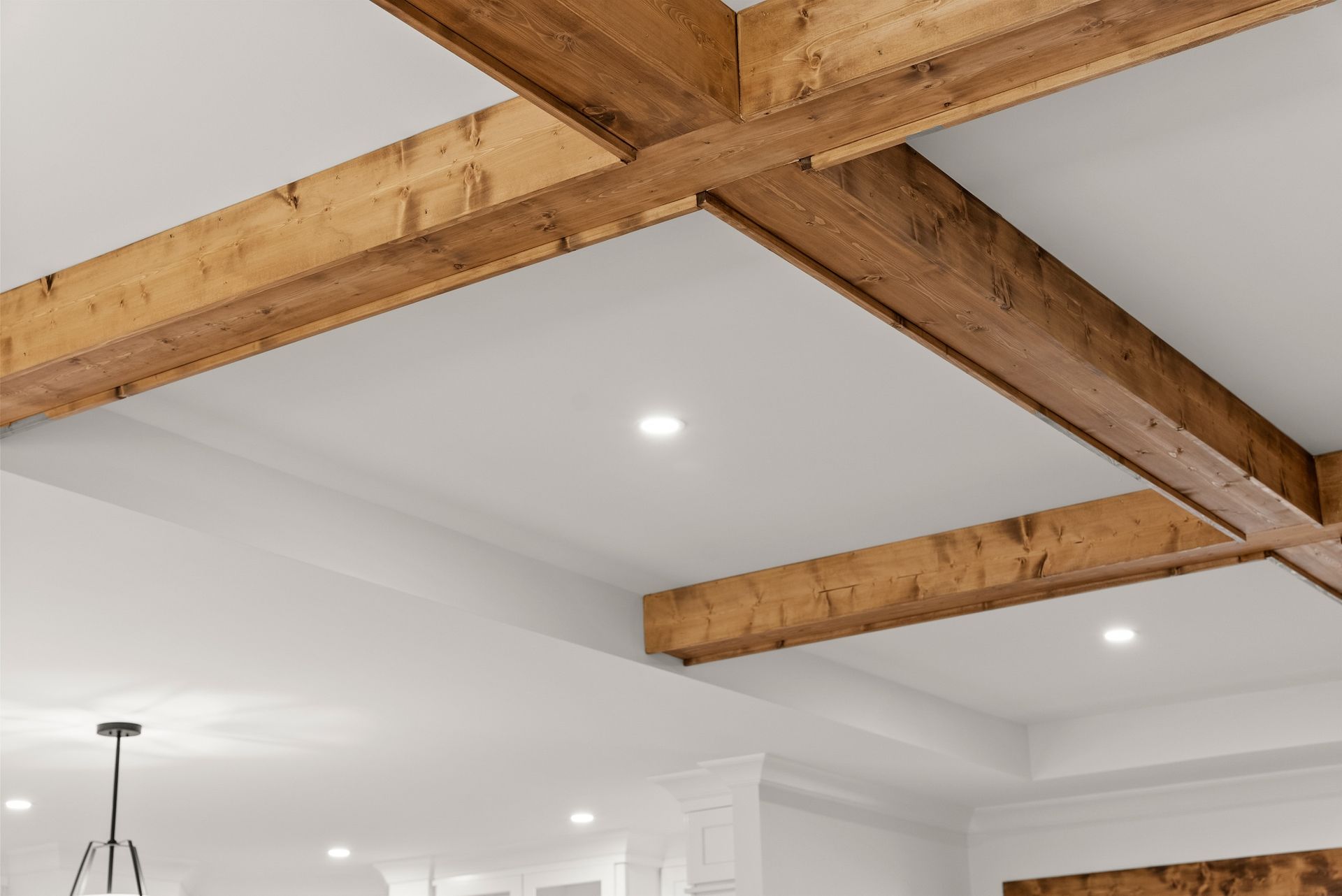 A kitchen with wooden beams on the ceiling and a chandelier hanging from the ceiling.