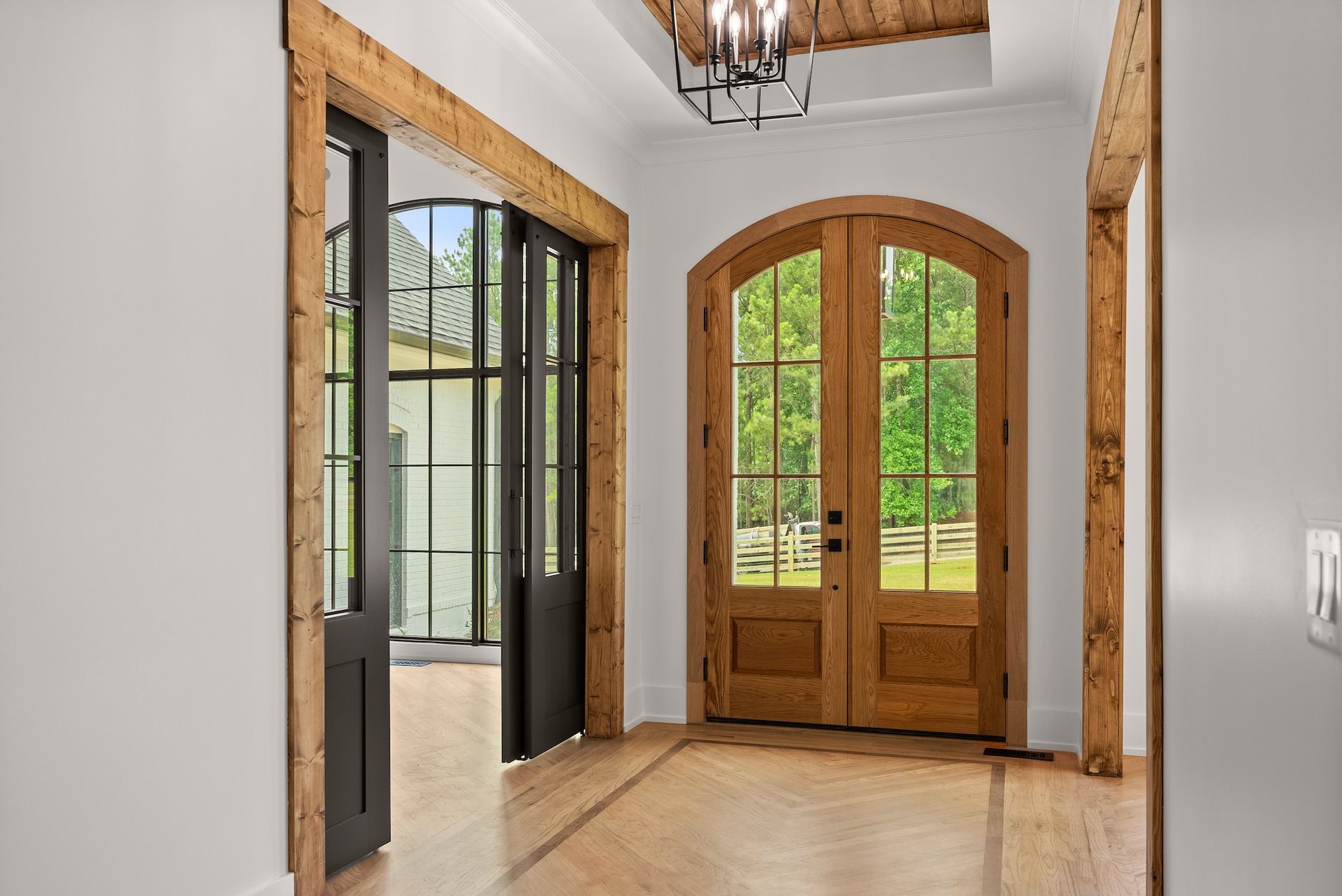 A hallway with wooden doors and windows in a house.
